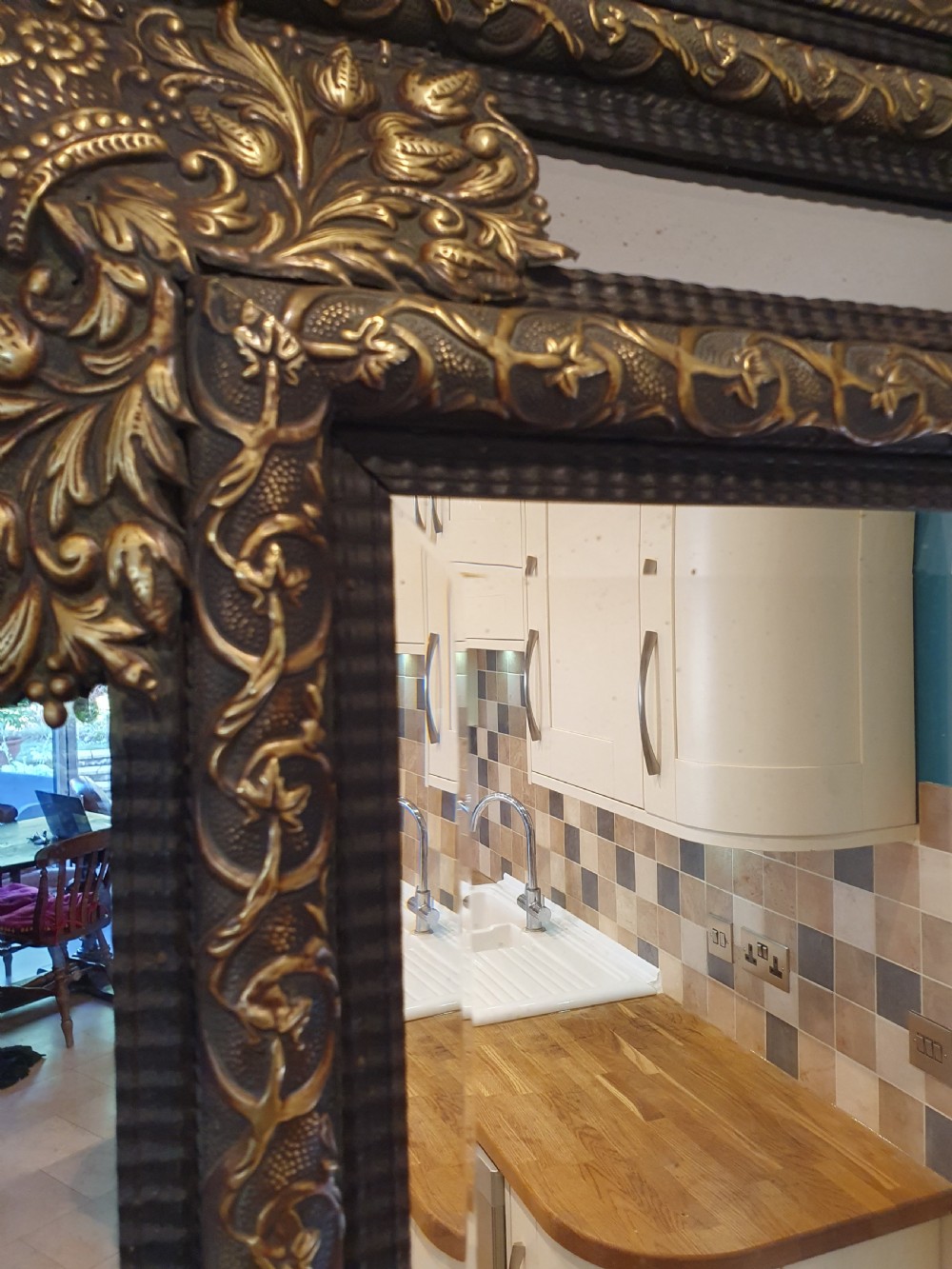 A late 19th-century rectangular Dutch wall mirror featuring an embossed brass frame with cushion moulding, intricate floral cresting, and bevelled glass. View II