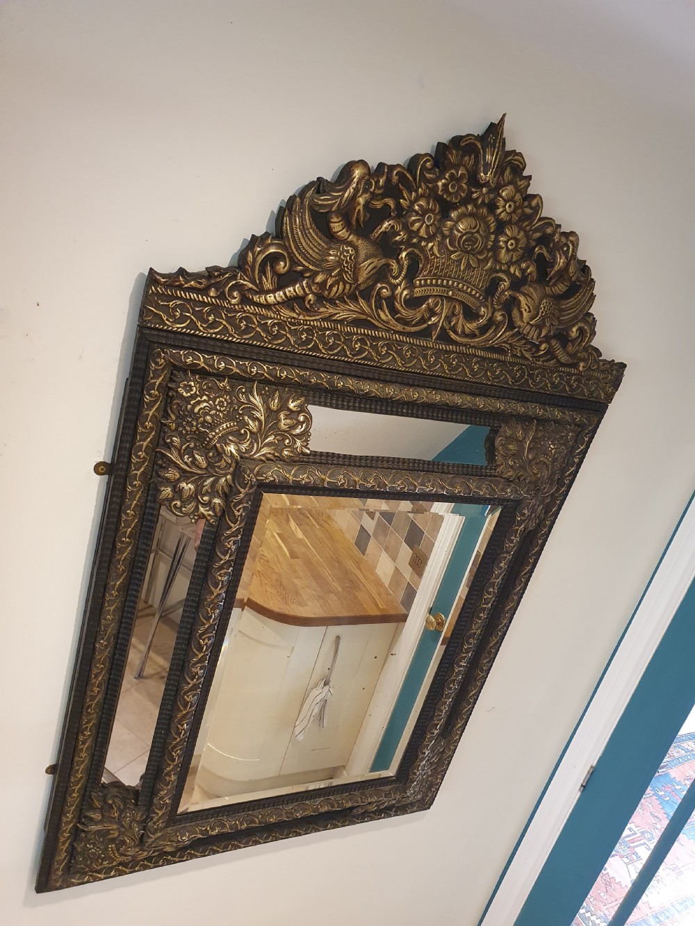 A late 19th-century rectangular Dutch wall mirror featuring an embossed brass frame with cushion moulding, intricate floral cresting, and bevelled glass. View VIII