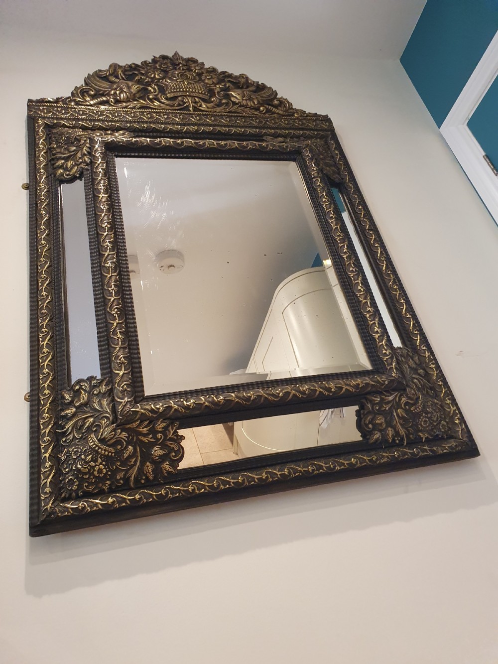 A late 19th-century rectangular Dutch wall mirror featuring an embossed brass frame with cushion moulding, intricate floral cresting, and bevelled glass. View IX