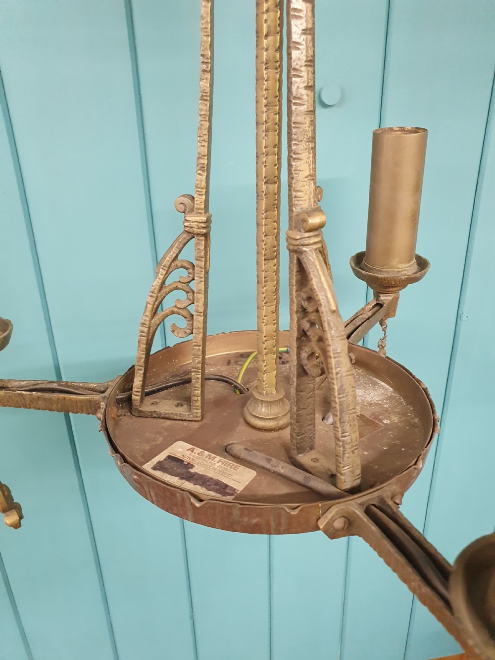 An Art Deco gilt brass three-arm chandelier featuring geometric central columns, candle-style bulb holders, and dangling teardrop accents. View VIII