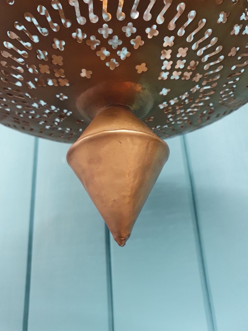 A flared bell-shaped pierced brass pendant light with geometric reticulated patterns suspended from a brass chain. View II