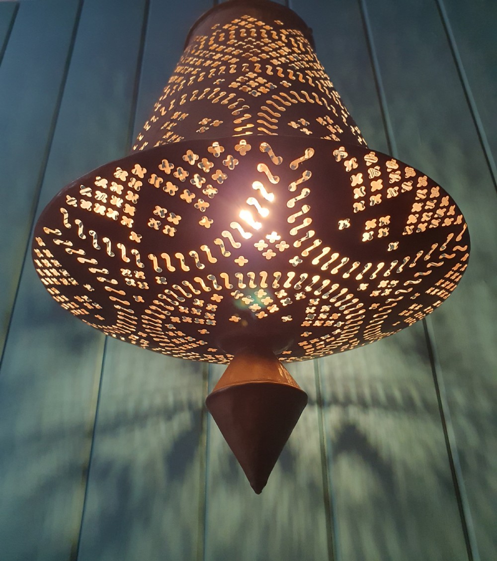 A flared bell-shaped pierced brass pendant light with geometric reticulated patterns suspended from a brass chain. View VII