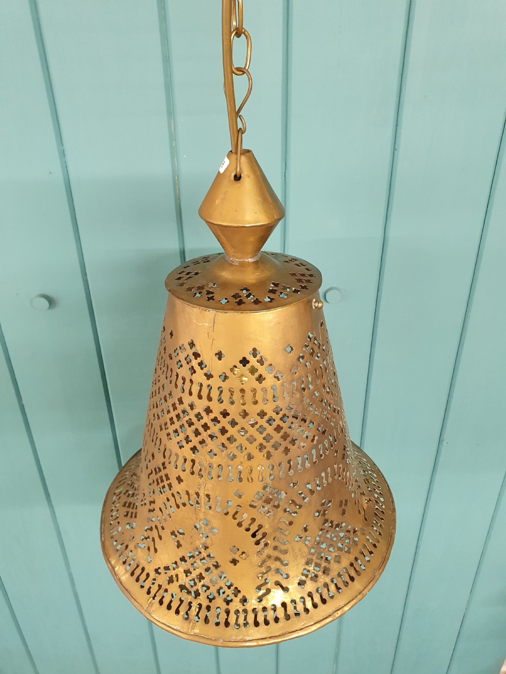 A flared bell-shaped pierced brass pendant light with geometric reticulated patterns suspended from a brass chain. View VIII