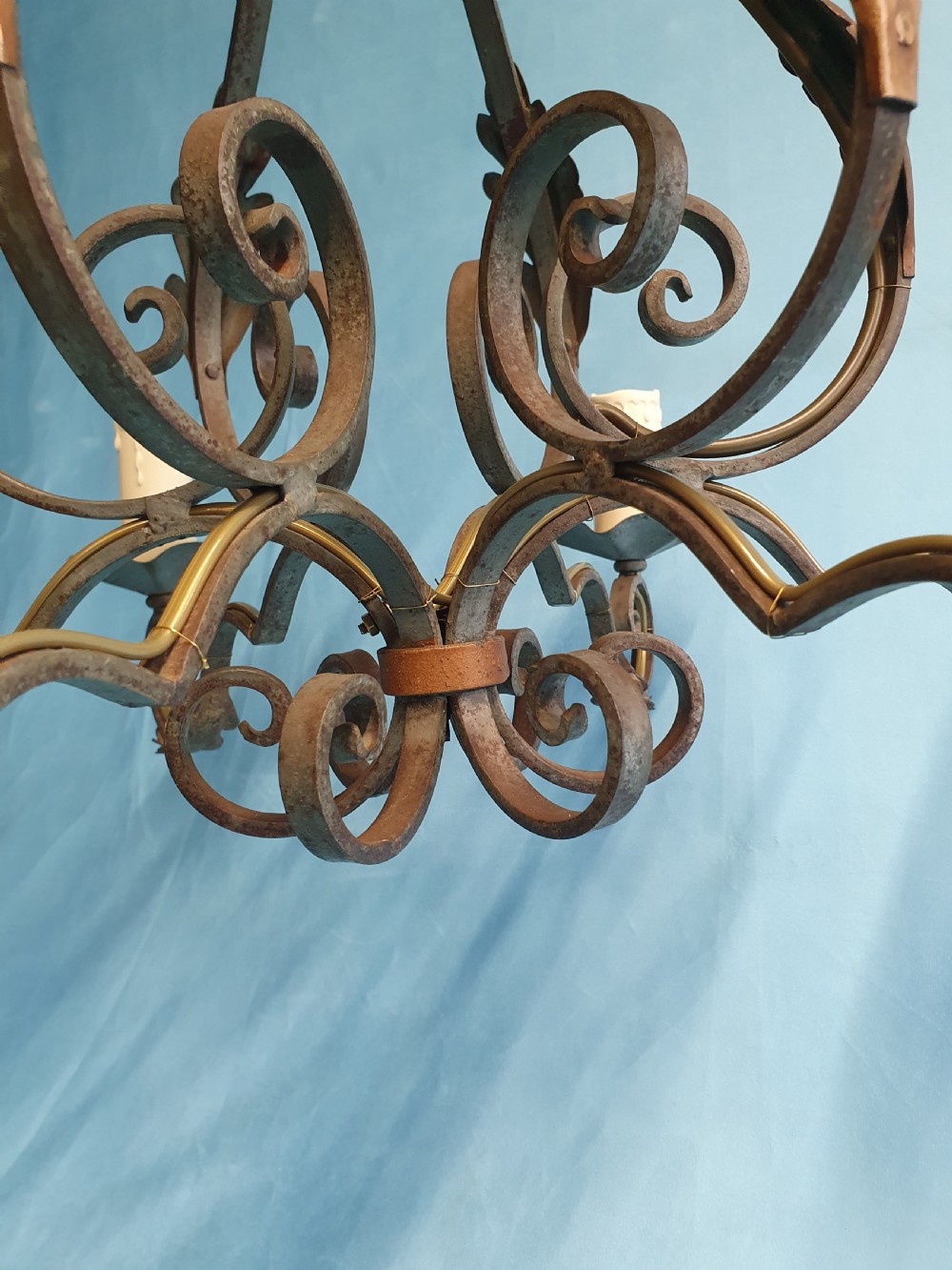A dark green six-arm wrought steel chandelier with scrollwork arms, candle sleeves, and dark lampshades. View III