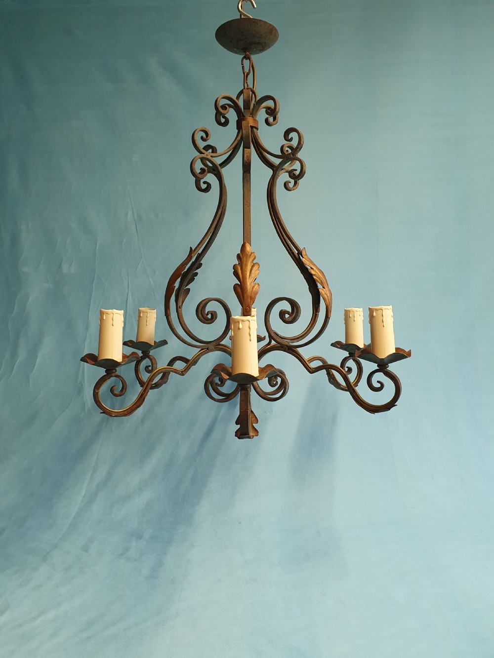 A dark green six-arm wrought steel chandelier with scrollwork arms, candle sleeves, and dark lampshades. View V
