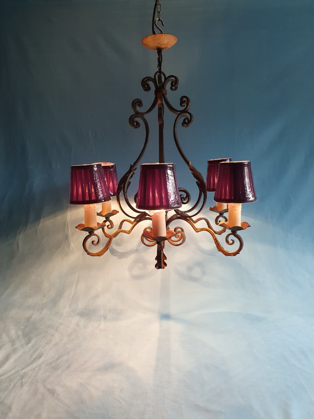 A dark green six-arm wrought steel chandelier with scrollwork arms, candle sleeves, and dark lampshades. View VI