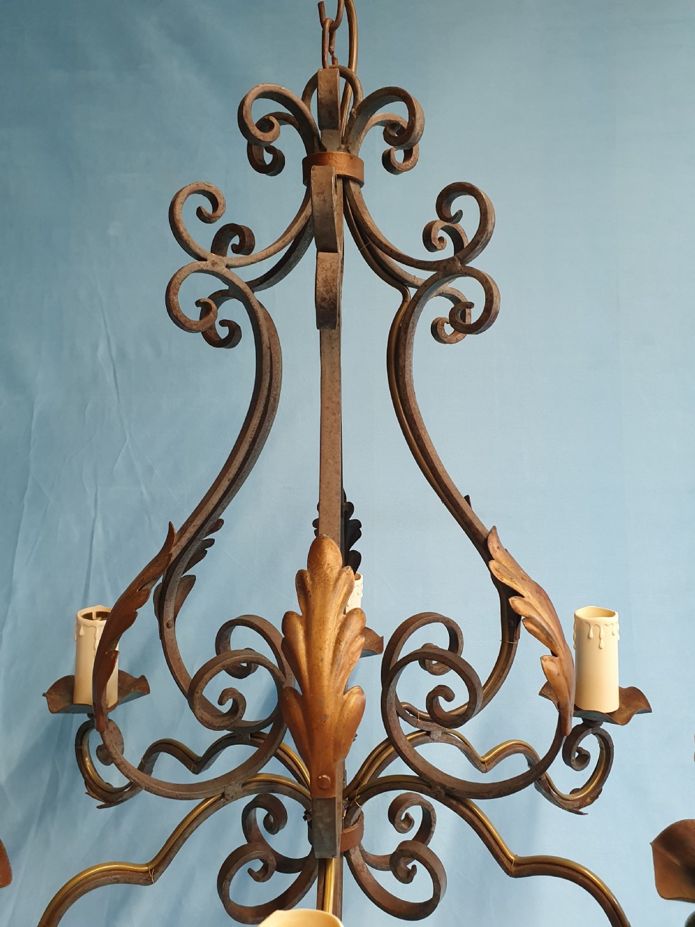 A dark green six-arm wrought steel chandelier with scrollwork arms, candle sleeves, and dark lampshades. View IX
