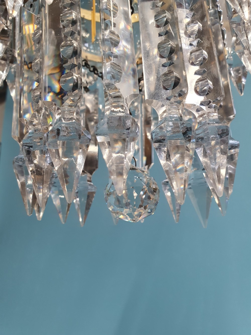 An early 20th-century brass ceiling pendant featuring tiered rows of faceted glass crystal droplets suspended by metal chains. View VII