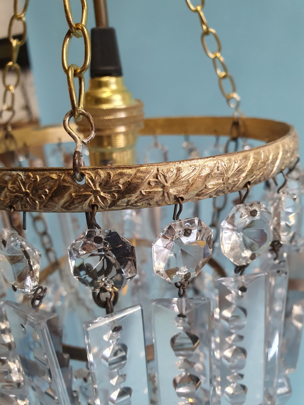 An early 20th-century brass ceiling pendant featuring tiered rows of faceted glass crystal droplets suspended by metal chains. View VIII