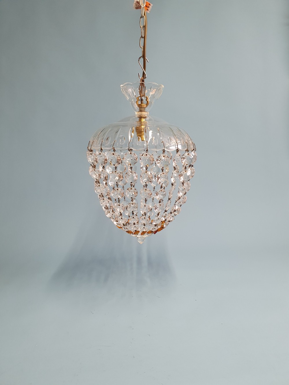 A small ceiling light with a clear glass dome top and cascading strands of faceted glass beads forming a tapered pendant shape.