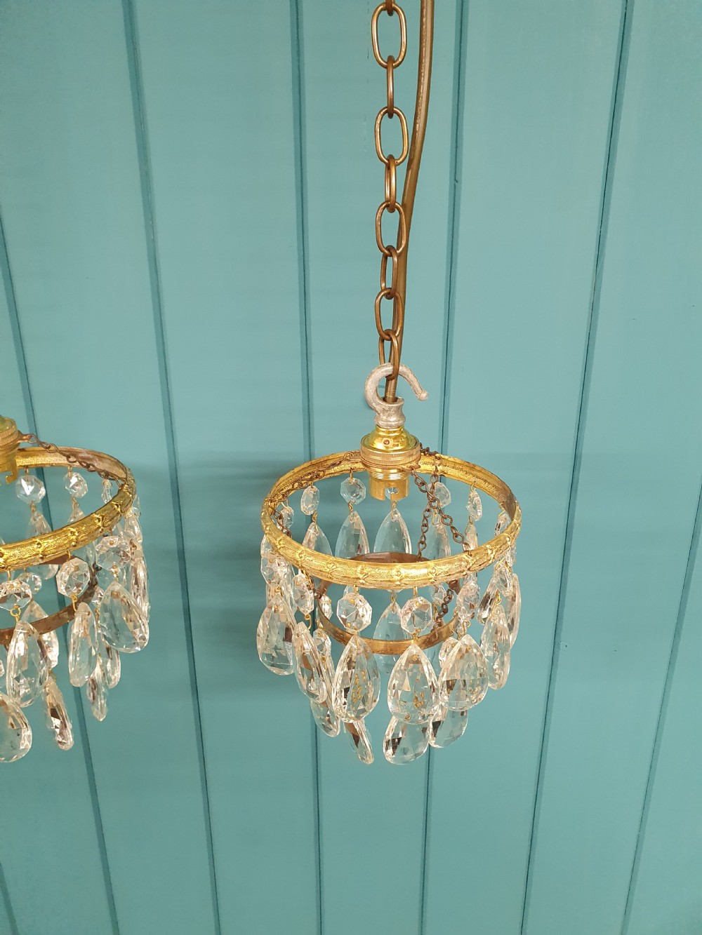 A pair of small early 20th-century brass ceiling pendant chandeliers featuring tiers of hanging faceted clear crystal droplets. View III