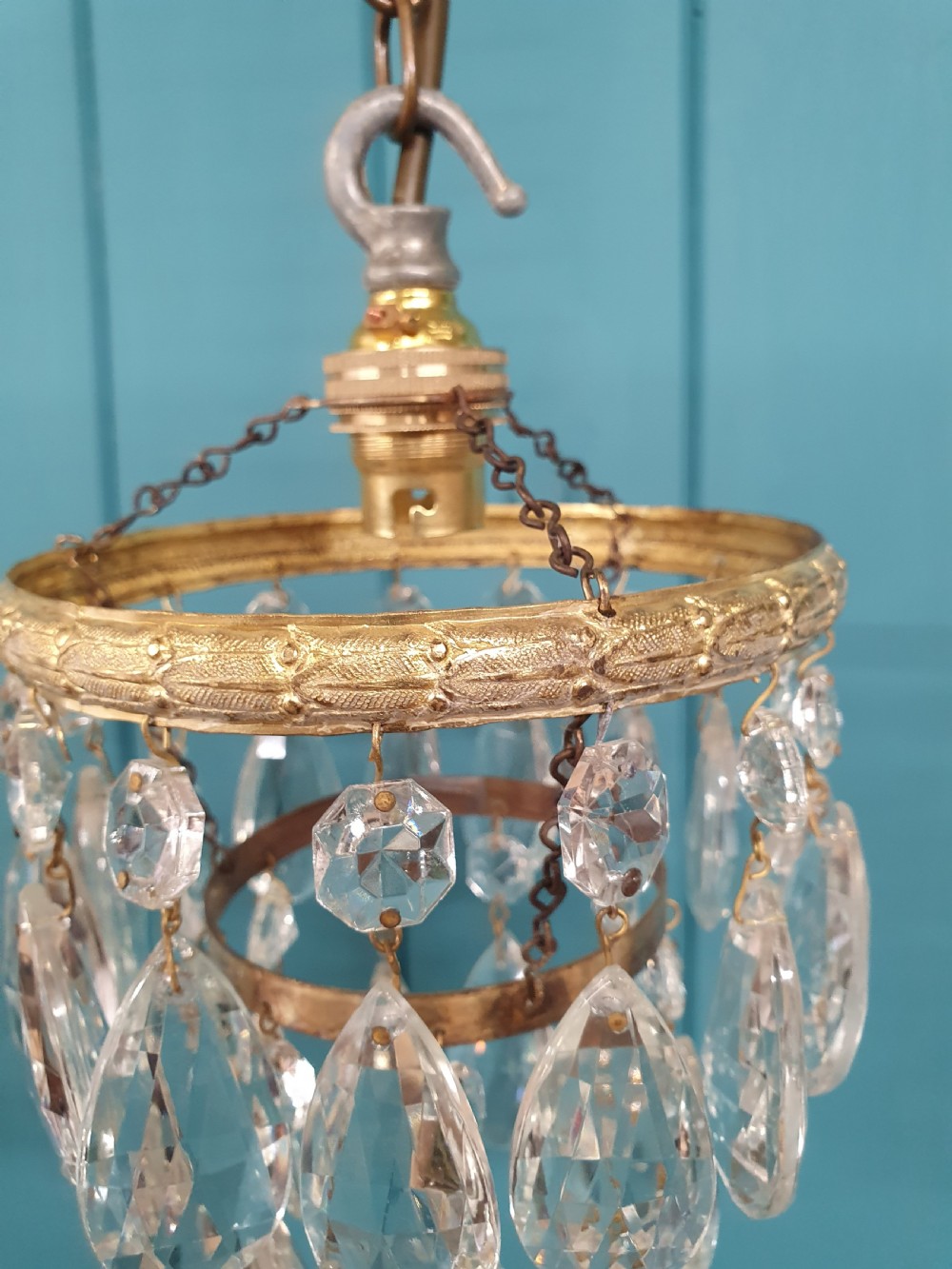 A pair of small early 20th-century brass ceiling pendant chandeliers featuring tiers of hanging faceted clear crystal droplets. View V