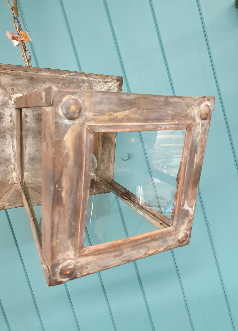 An early 20th-century patinated brass pendant lantern with clear glass side panels suspended by a chain. View VIII