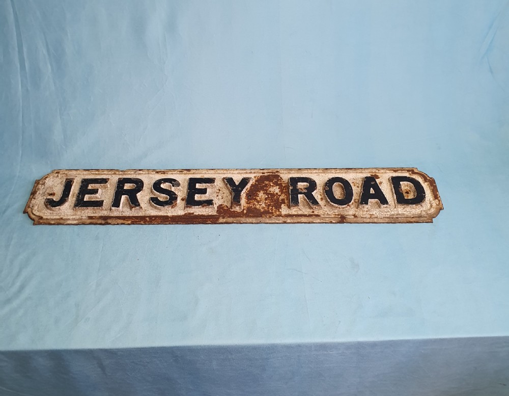 A late nineteenth-century rectangular cast iron street sign featuring raised black lettering reading JERSEY ROAD against a weathered off-white painted background.