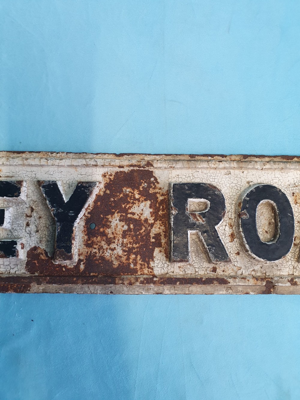 A late nineteenth-century rectangular cast iron street sign featuring raised black lettering reading JERSEY ROAD against a weathered off-white painted background. View III