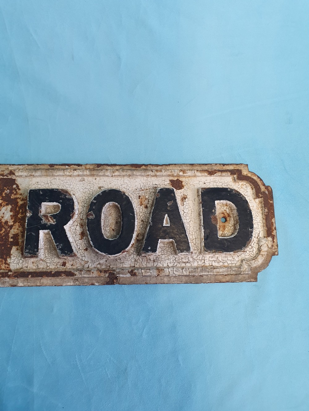 A late nineteenth-century rectangular cast iron street sign featuring raised black lettering reading JERSEY ROAD against a weathered off-white painted background. View V