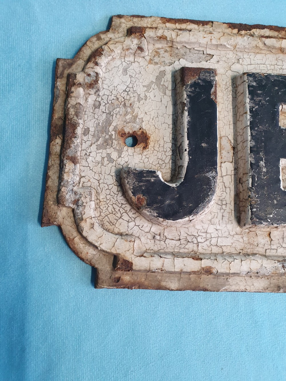 A late nineteenth-century rectangular cast iron street sign featuring raised black lettering reading JERSEY ROAD against a weathered off-white painted background. View VII