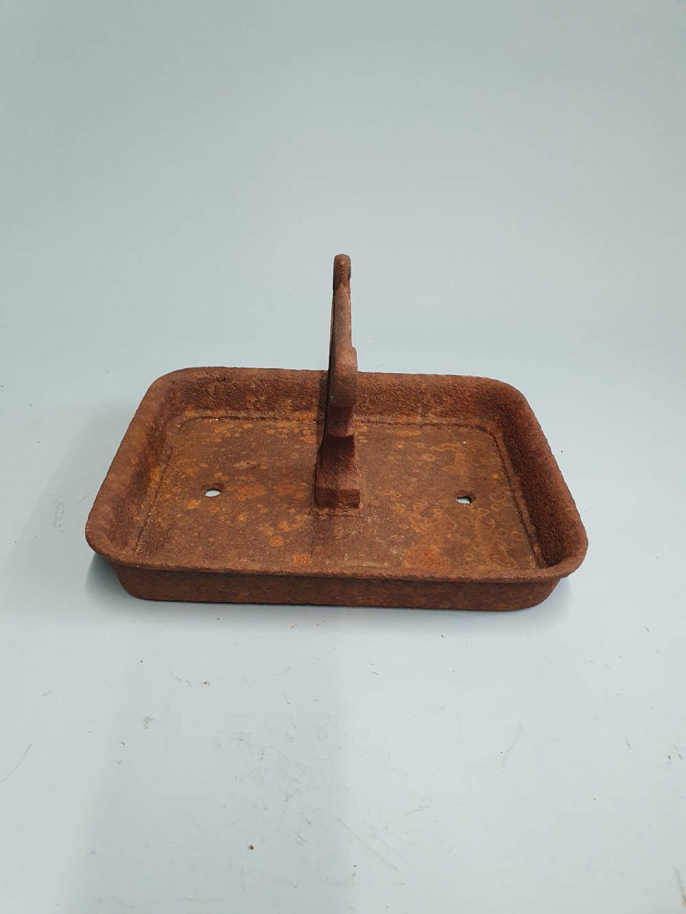 A late nineteenth-century cast iron boot scraper featuring a rectangular drip tray base and a scroll-detailed scraping blade with heavy rusted patina. View III