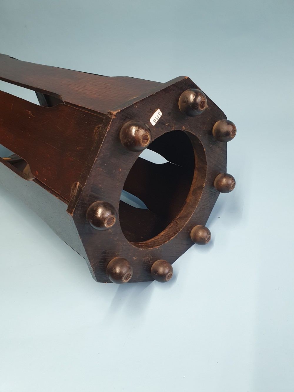 An early 20th-century dark wood octagonal stick stand featuring slatted vertical panels and an internal circular divider ring. View II