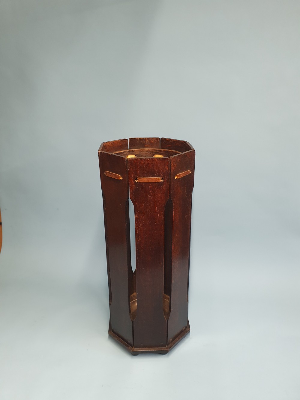 An early 20th-century dark wood octagonal stick stand featuring slatted vertical panels and an internal circular divider ring. View III
