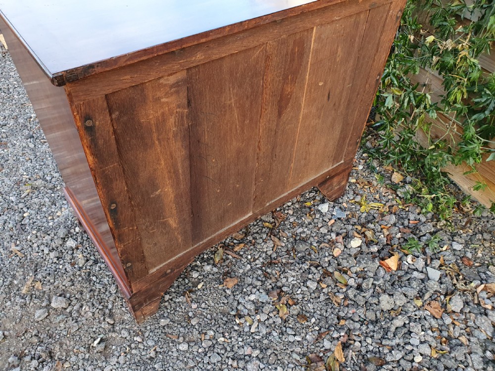 A Georgian mahogany serpentine chest of drawers featuring a curved three-drawer front, brass swan-neck handles, and shaped bracket feet. View IX