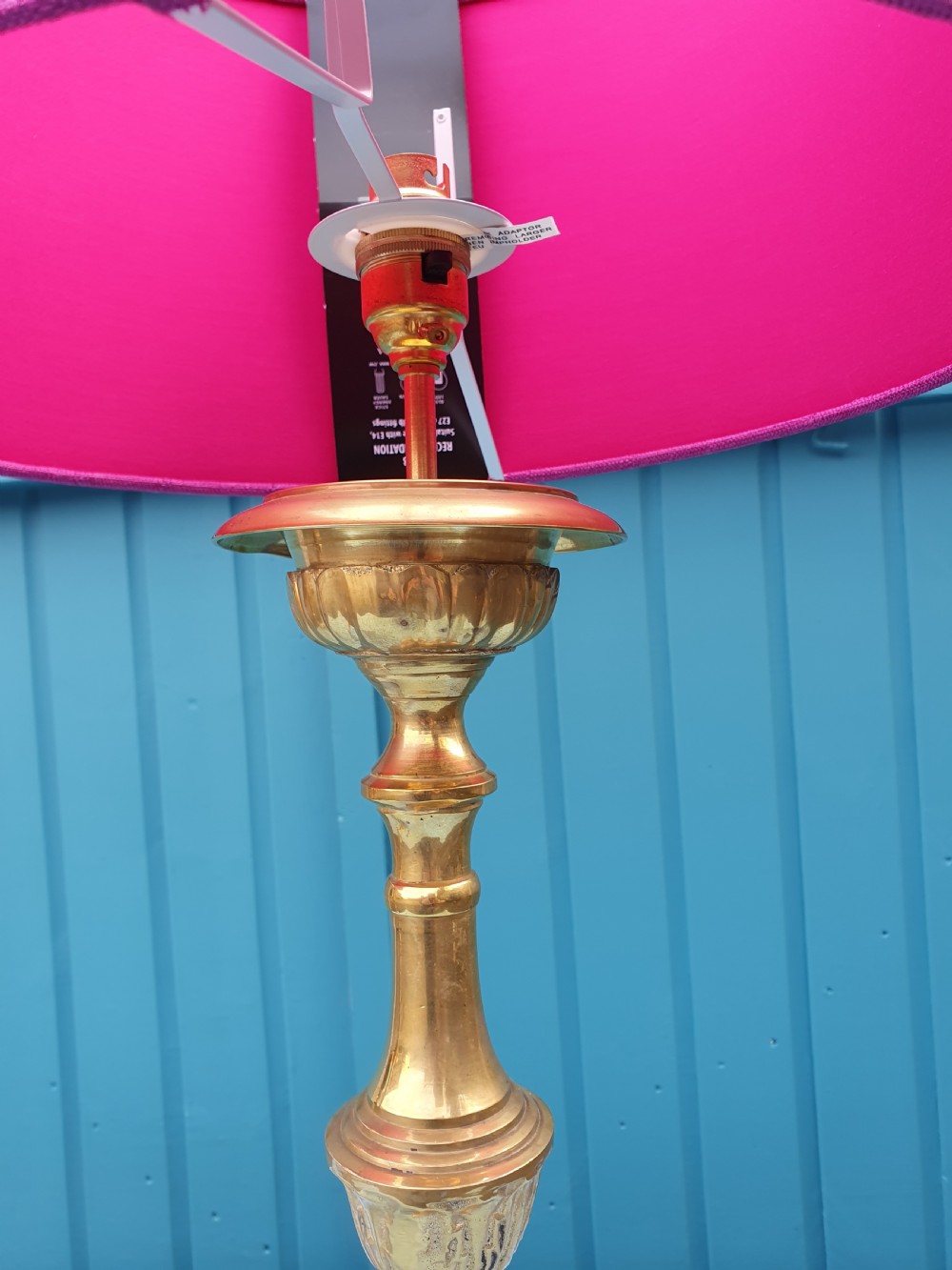 A pair of ornate cast brass candlestick-style table lamps fitted with bright pink fabric drum shades. View VII