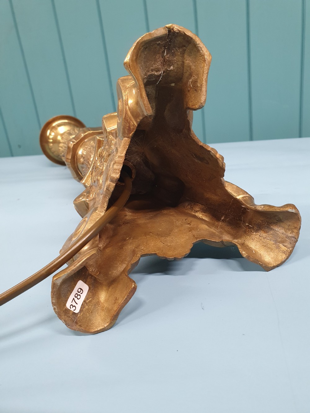An early 20th-century Baroque revival cast brass candlestick table lamp with a scrolled tripod base and turned stem. View II