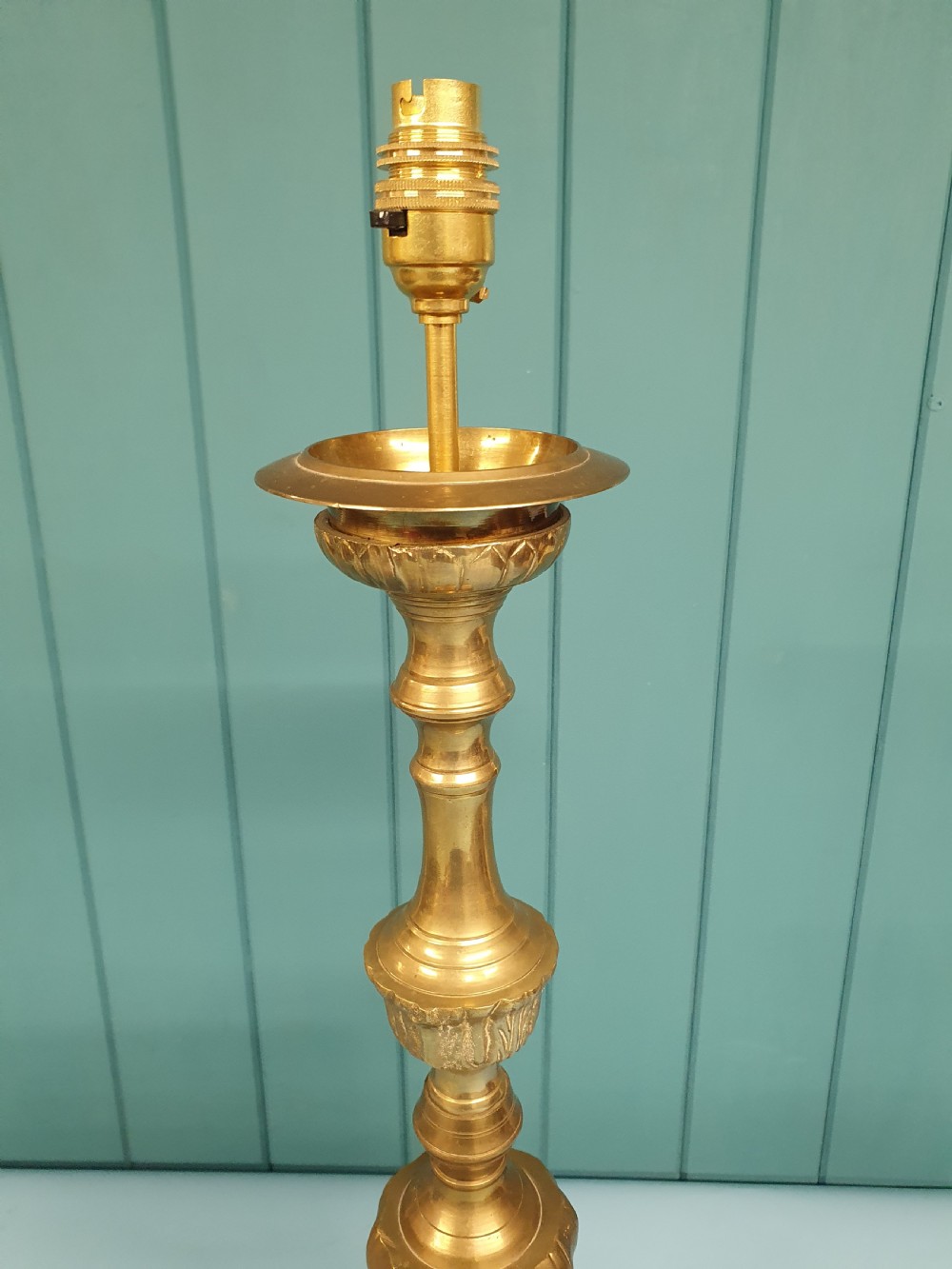 An early 20th-century Baroque revival cast brass candlestick table lamp with a scrolled tripod base and turned stem. View V