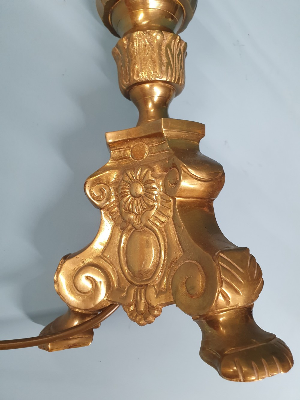 An early 20th-century Baroque revival cast brass candlestick table lamp with a scrolled tripod base and turned stem. View VII