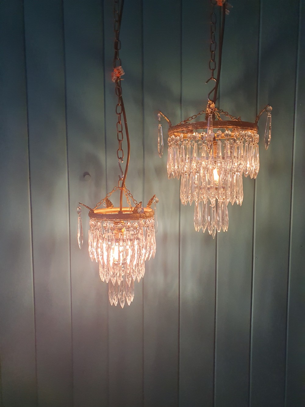 A pair of small early 20th-century gilded brass chandeliers featuring cascading tiers of crystal glass spikes. View VI