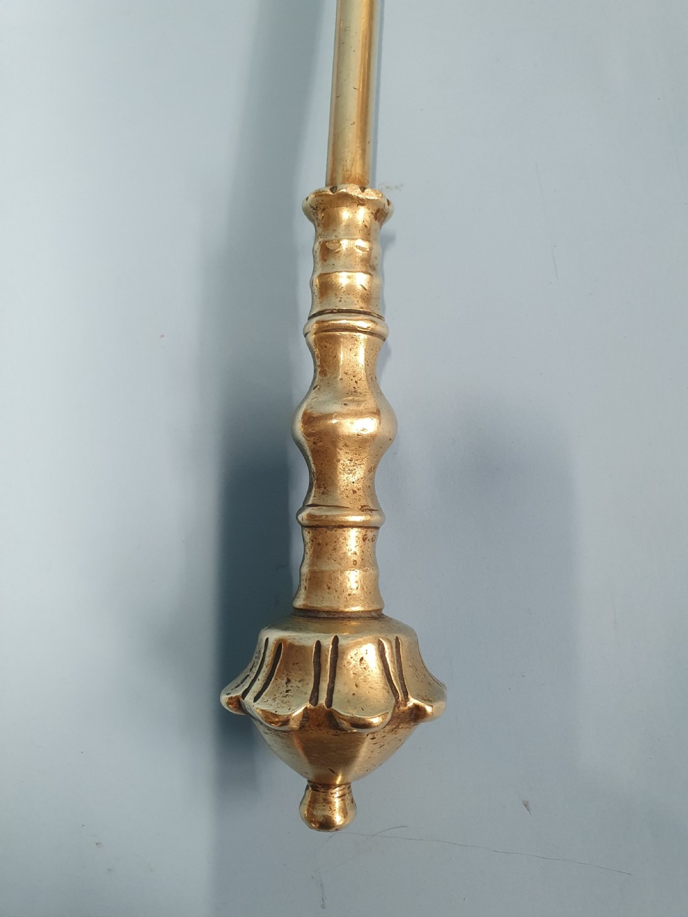 A three-piece set of 19th-century brass fire tools comprising a poker, tongs, and an ornamental shovel with a decorative pierced pattern. View VII