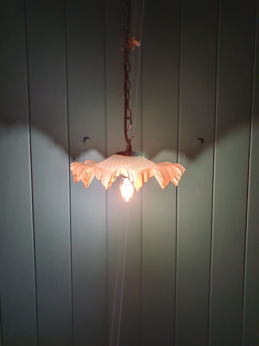 An antique French ceiling pendant featuring a frosted amber glass shade with a ruffled frilled rim suspended from a brass link chain. View IV