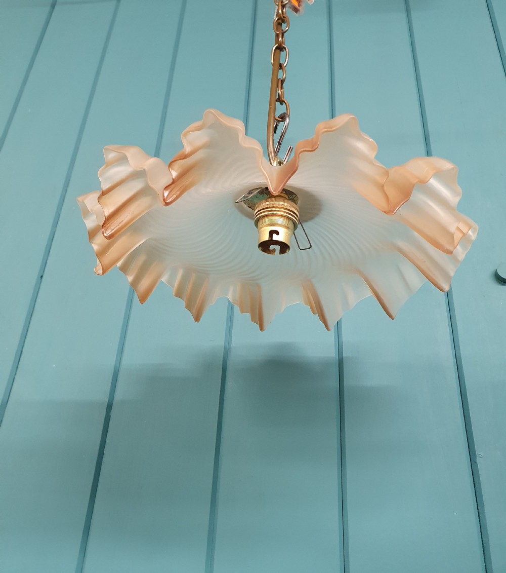 An antique French ceiling pendant featuring a frosted amber glass shade with a ruffled frilled rim suspended from a brass link chain. View VI