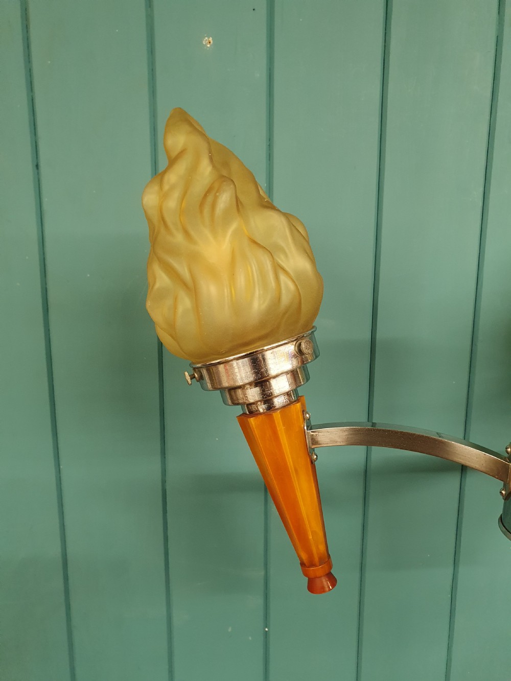 An Art Deco three-light chandelier featuring chrome stems, orange torch holders, and flame-shaped frosted glass shades. View IV
