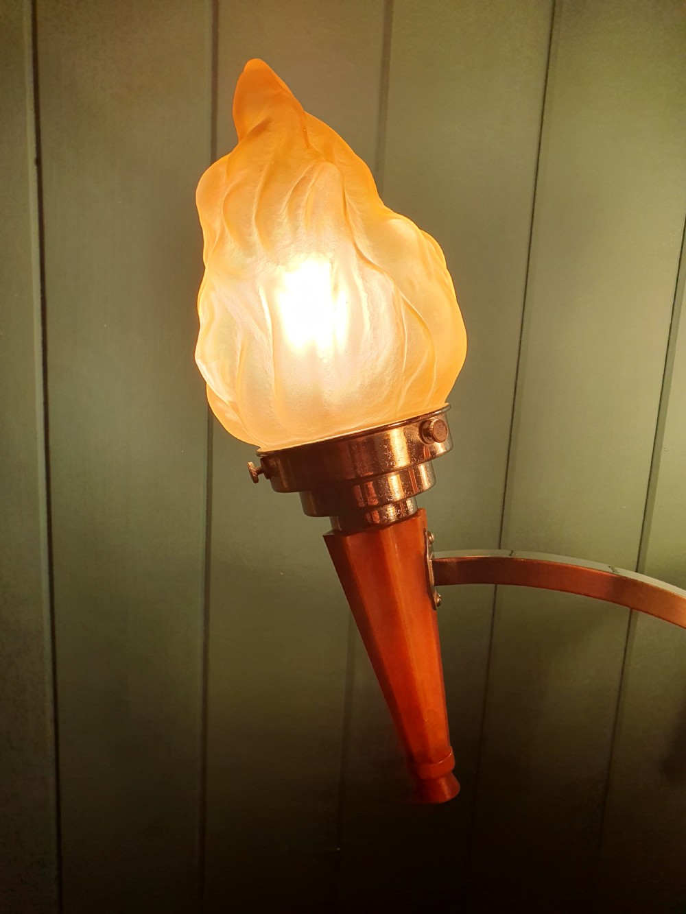 An Art Deco three-light chandelier featuring chrome stems, orange torch holders, and flame-shaped frosted glass shades. View VI