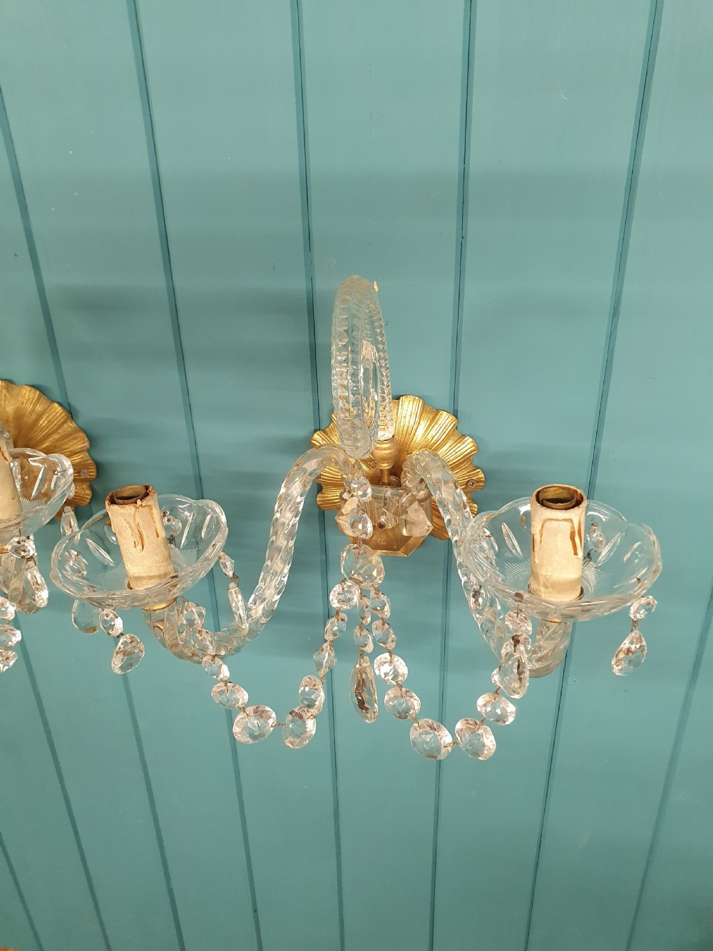 A pair of early 20th-century French double-arm glass wall sconces with crystal droplets, gilt brass backplates, and black lampshades. View II
