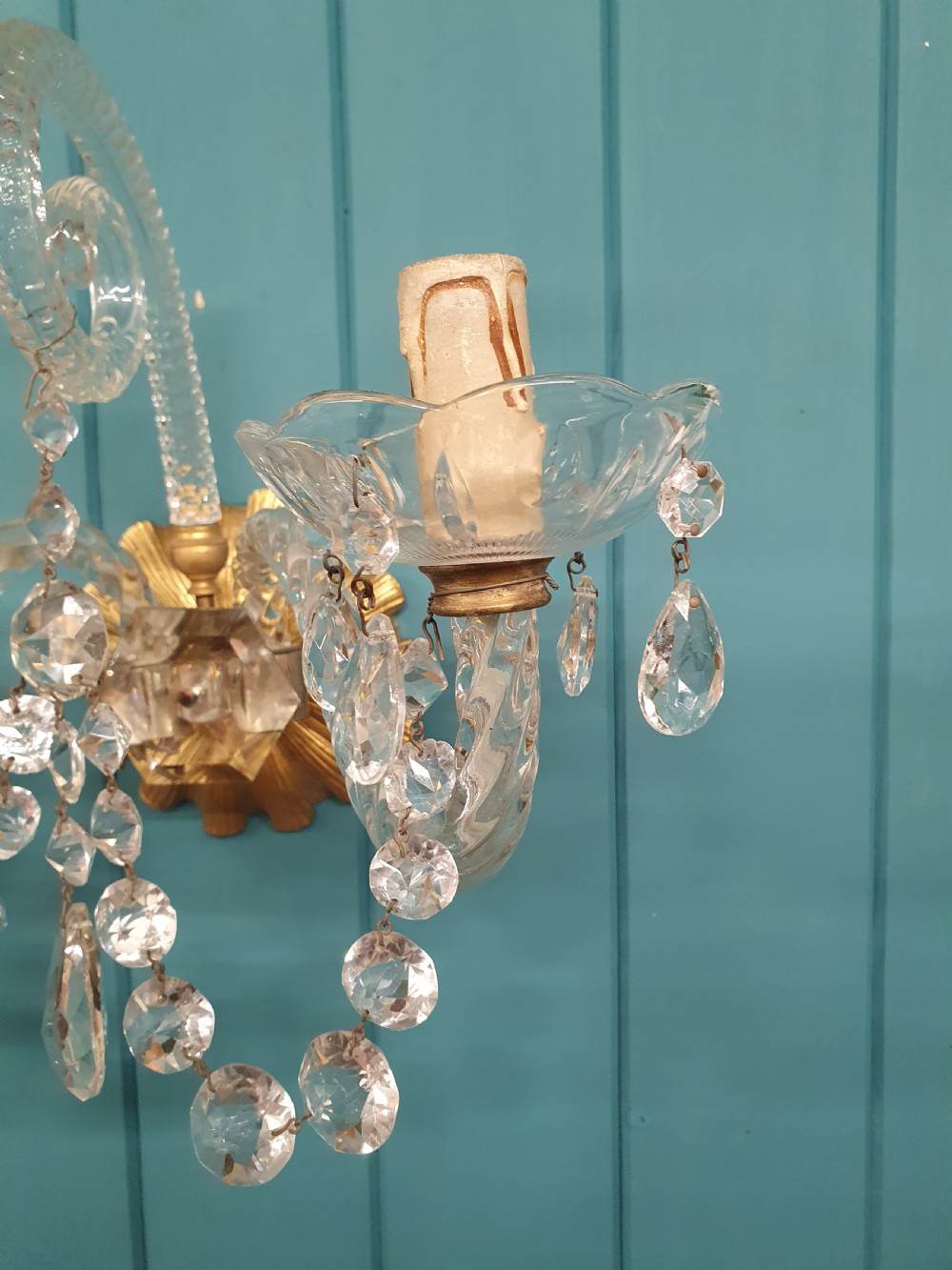 A pair of early 20th-century French double-arm glass wall sconces with crystal droplets, gilt brass backplates, and black lampshades. View III