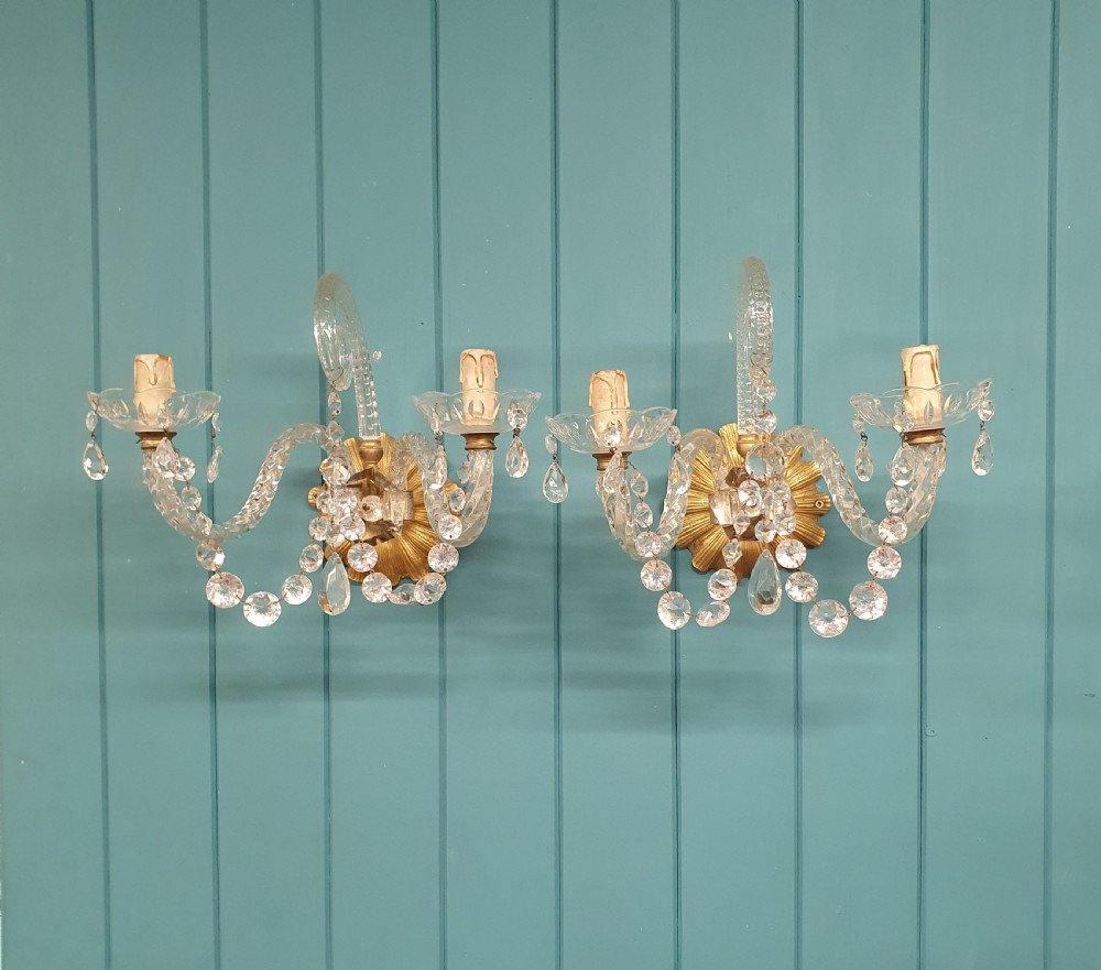A pair of early 20th-century French double-arm glass wall sconces with crystal droplets, gilt brass backplates, and black lampshades. View VII