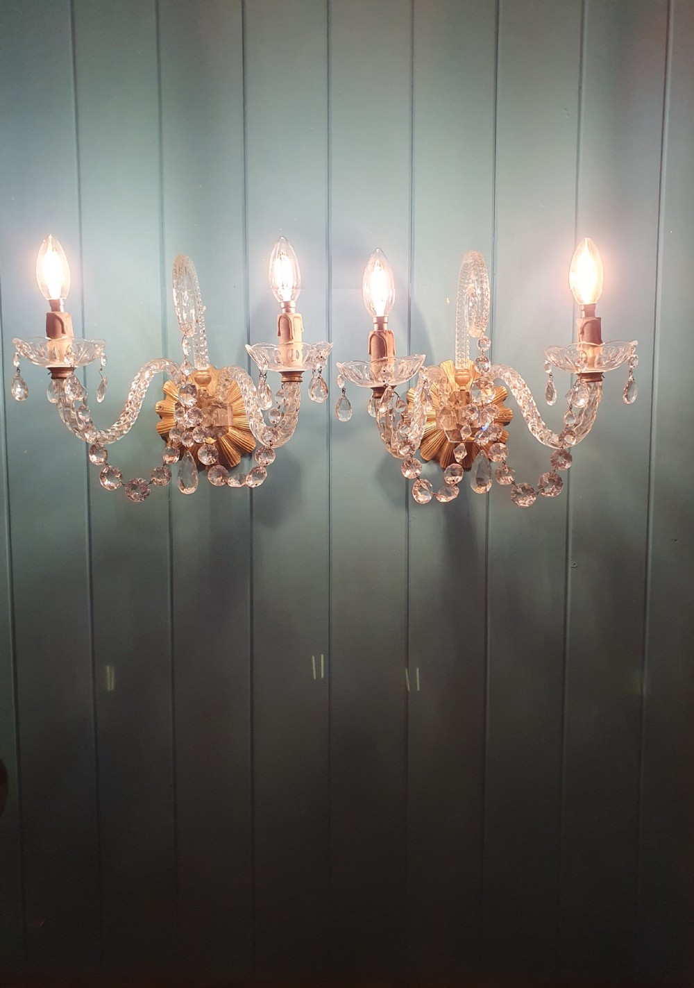 A pair of early 20th-century French double-arm glass wall sconces with crystal droplets, gilt brass backplates, and black lampshades. View VIII