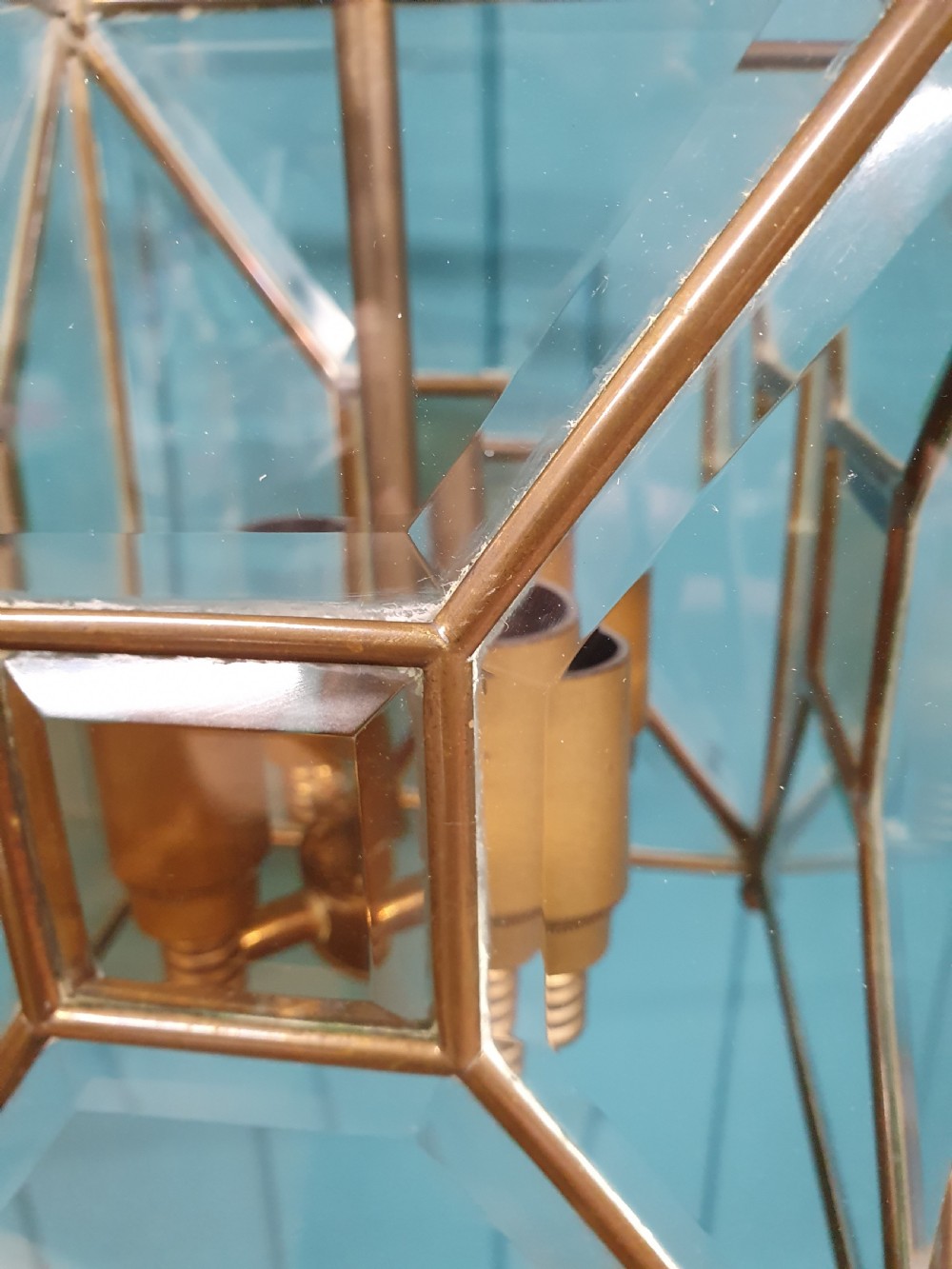 A square brass Arts and Crafts hall lantern featuring geometric bevelled glass panels suspended from a brass chain. View III