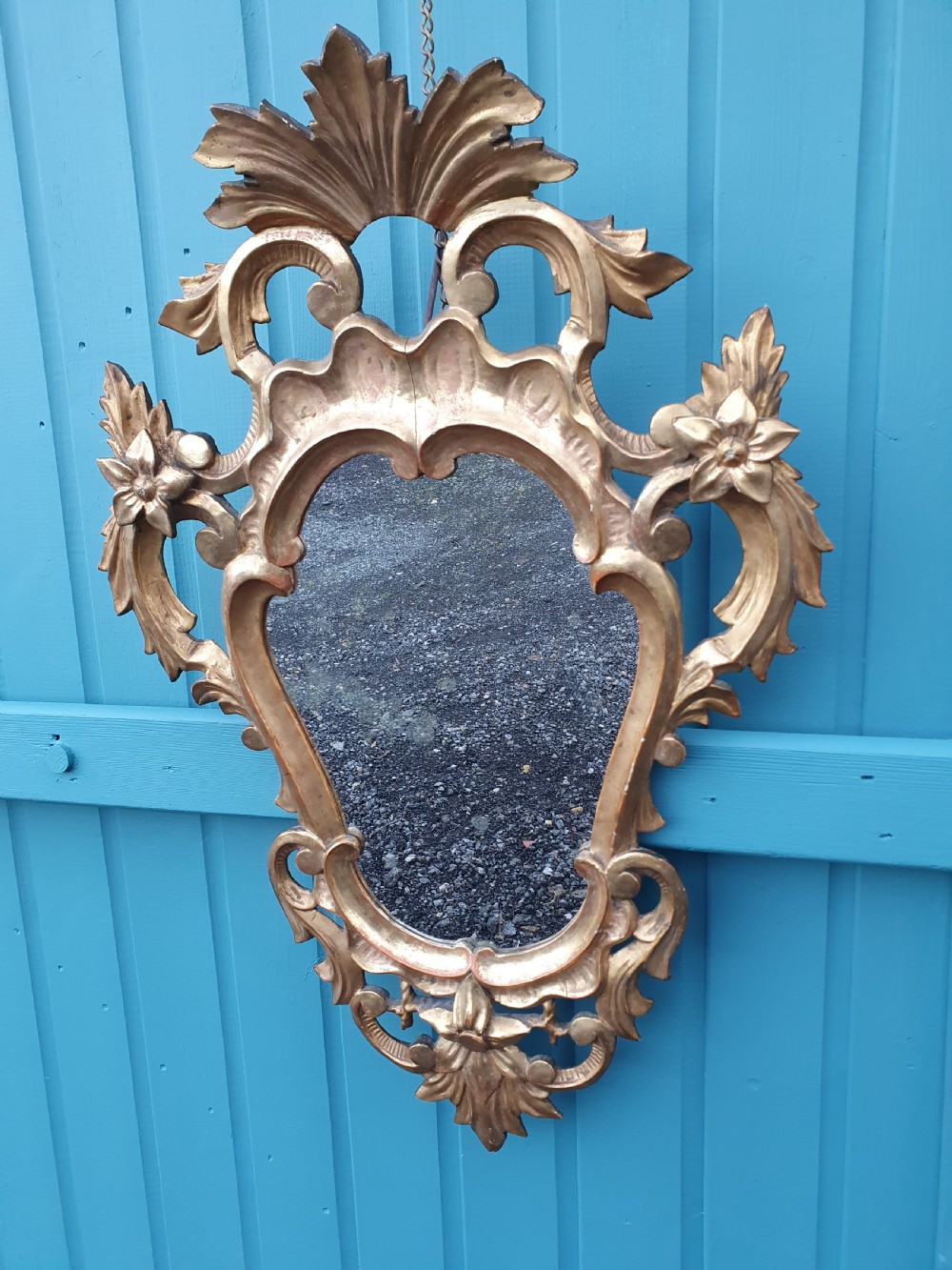 A matching pair of carved Italian Rococo style giltwood wall mirrors featuring leaf crests and elaborate floral scrollwork. View III