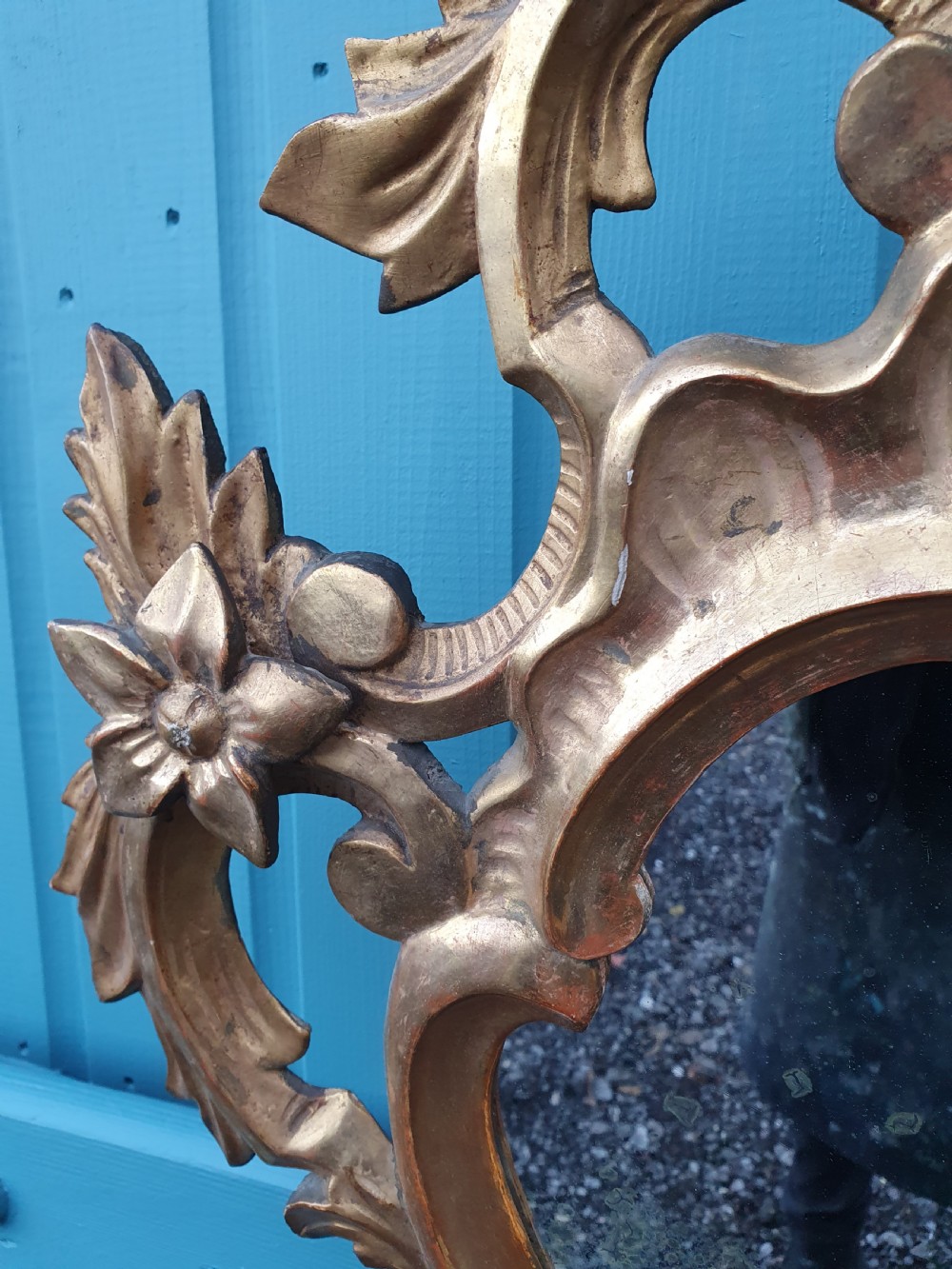 A matching pair of carved Italian Rococo style giltwood wall mirrors featuring leaf crests and elaborate floral scrollwork. View VII