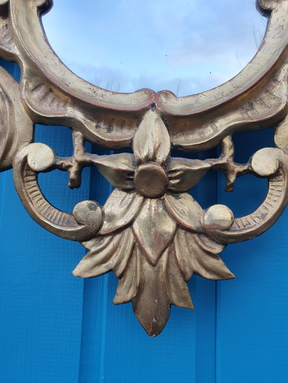 A matching pair of carved Italian Rococo style giltwood wall mirrors featuring leaf crests and elaborate floral scrollwork. View IX