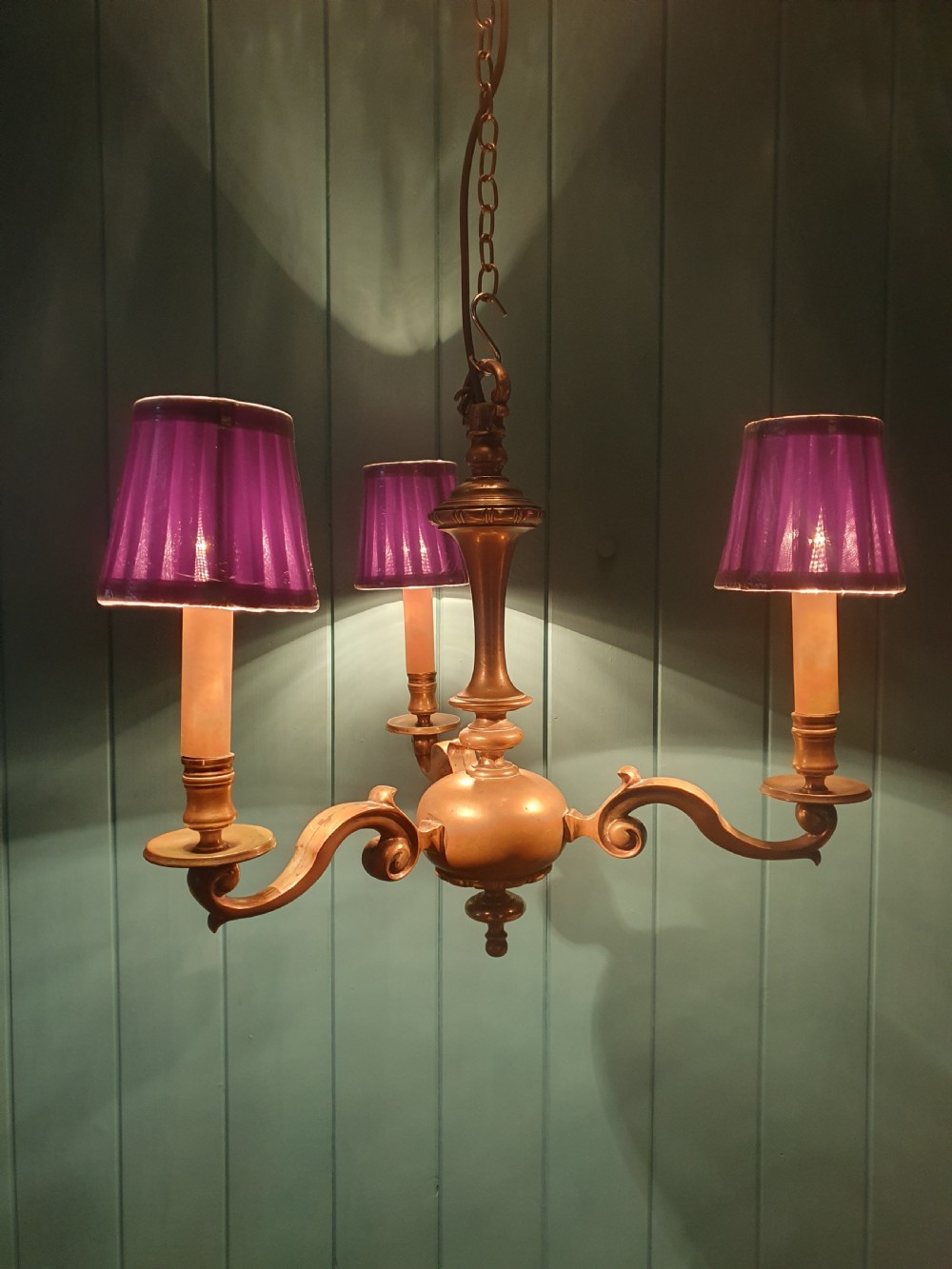 A three-arm Dutch Flemish style brass chandelier featuring a central turned baluster stem and s-scroll arms supporting faux candle sockets. View II