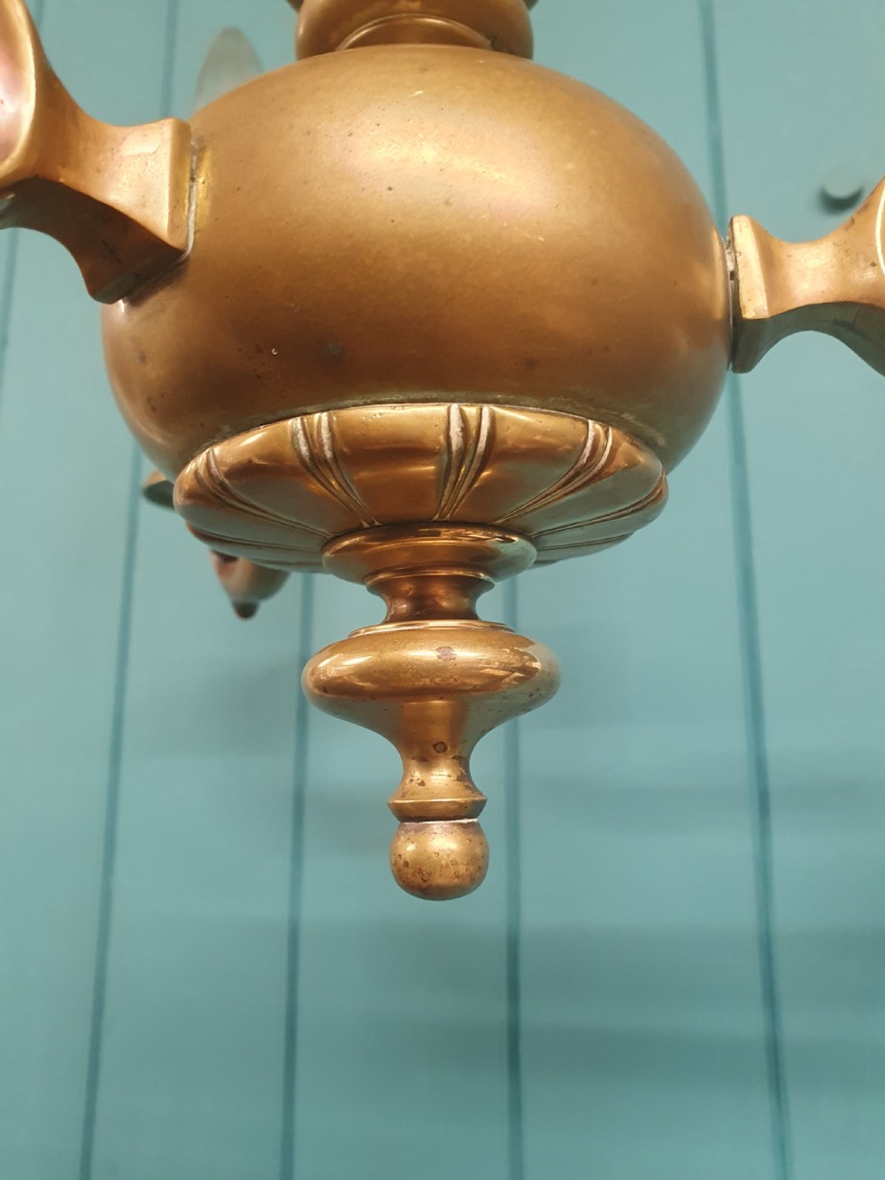 A three-arm Dutch Flemish style brass chandelier featuring a central turned baluster stem and s-scroll arms supporting faux candle sockets. View VI