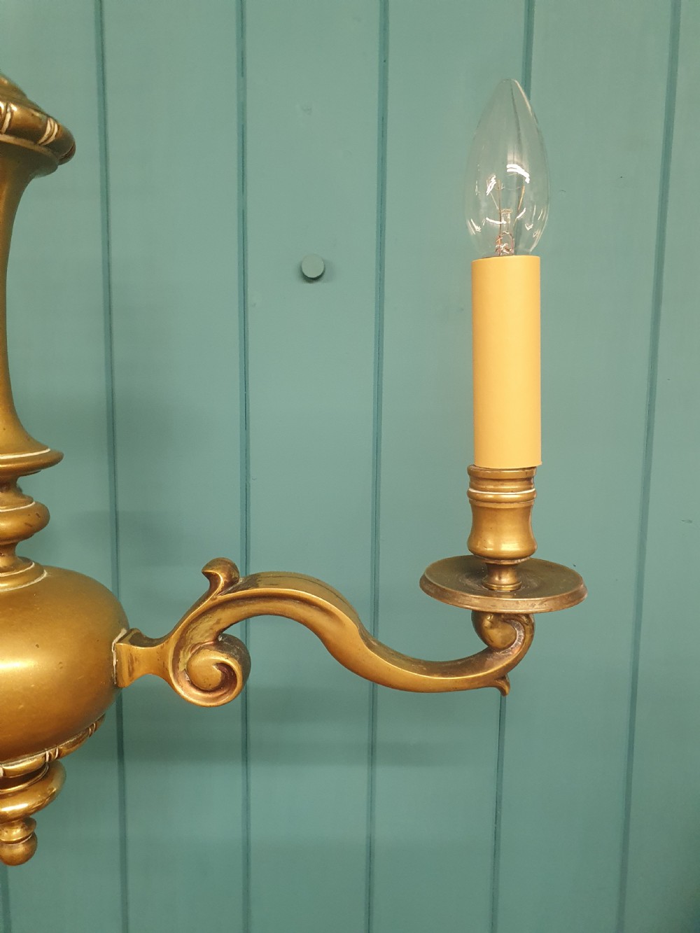 A three-arm Dutch Flemish style brass chandelier featuring a central turned baluster stem and s-scroll arms supporting faux candle sockets. View VIII