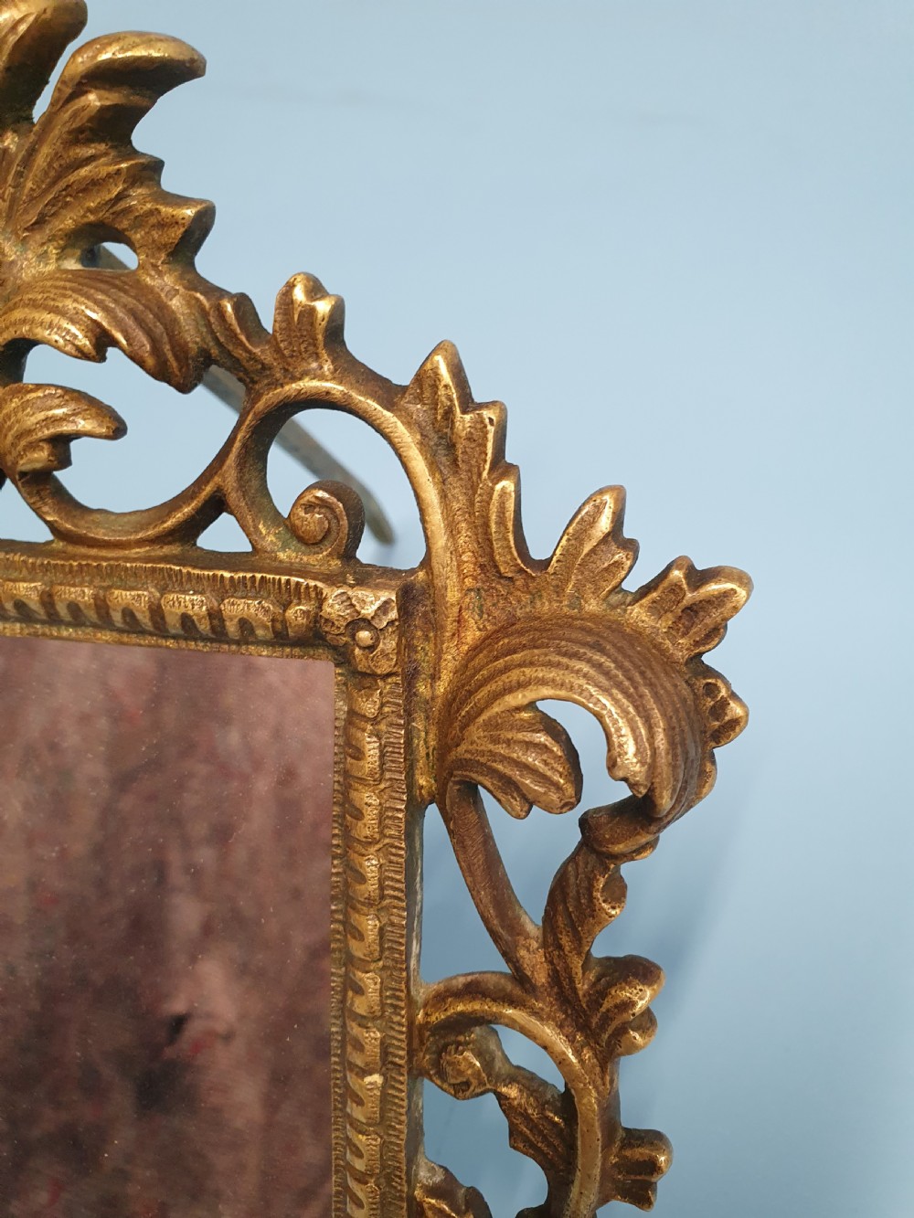 An ornate late 19th-century cast brass table mirror featuring pierced scrollwork frame and an acanthus leaf crest. View VI