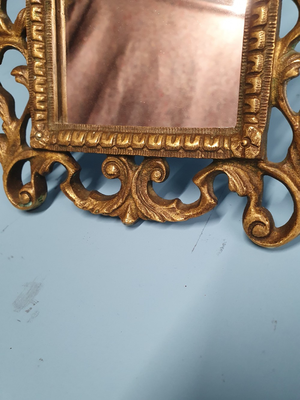 An ornate late 19th-century cast brass table mirror featuring pierced scrollwork frame and an acanthus leaf crest. View VII