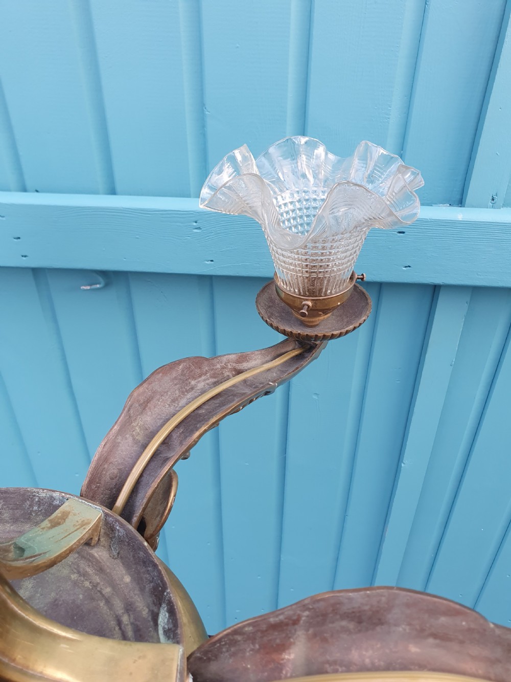 An early 20th-century six-arm brass ceiling chandelier featuring frilled clear glass shades and a central cast brass stem. View III