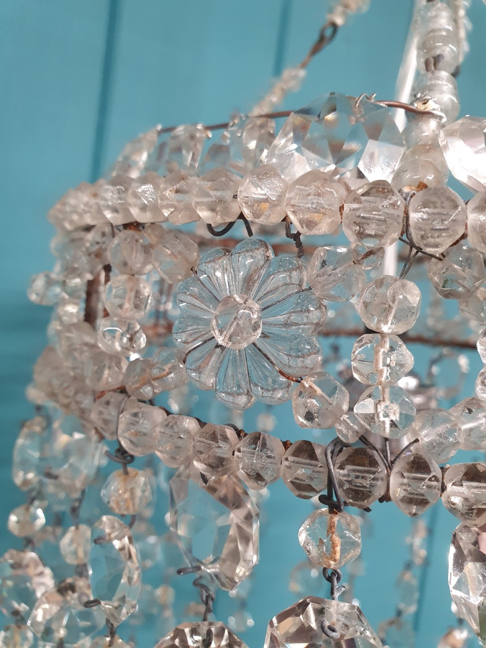 A small cylindrical ceiling light shade constructed from clear glass beads on a wire frame, featuring floral pattern bands and cascading faceted bead strands. View II